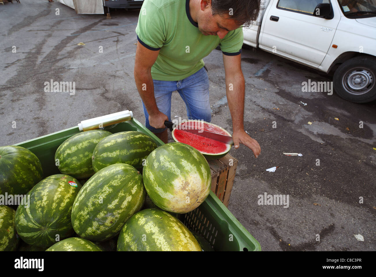 Un venditore di frutta prepara il melone di acqua alla strada del mercato di Sulmona, Italia. Foto Stock