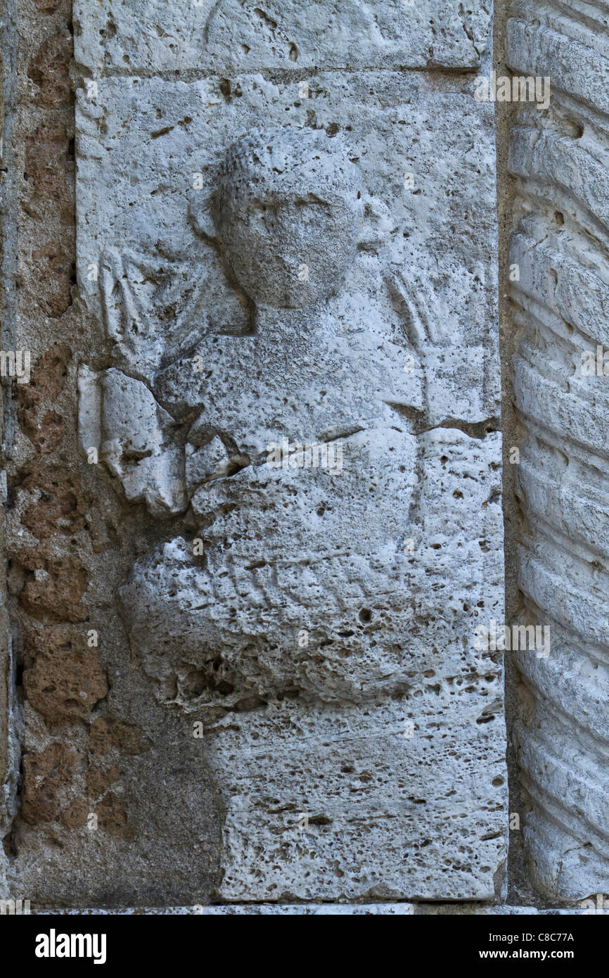 Scultura in pietra sul lato esterno del duomo di Sovana, Toscana, Italia Foto Stock