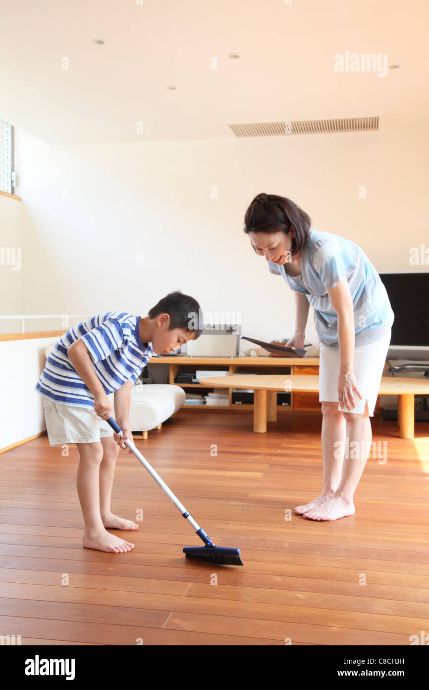 La madre del ragazzo e spazzare il pavimento con la scopa e paletta Foto  stock - Alamy