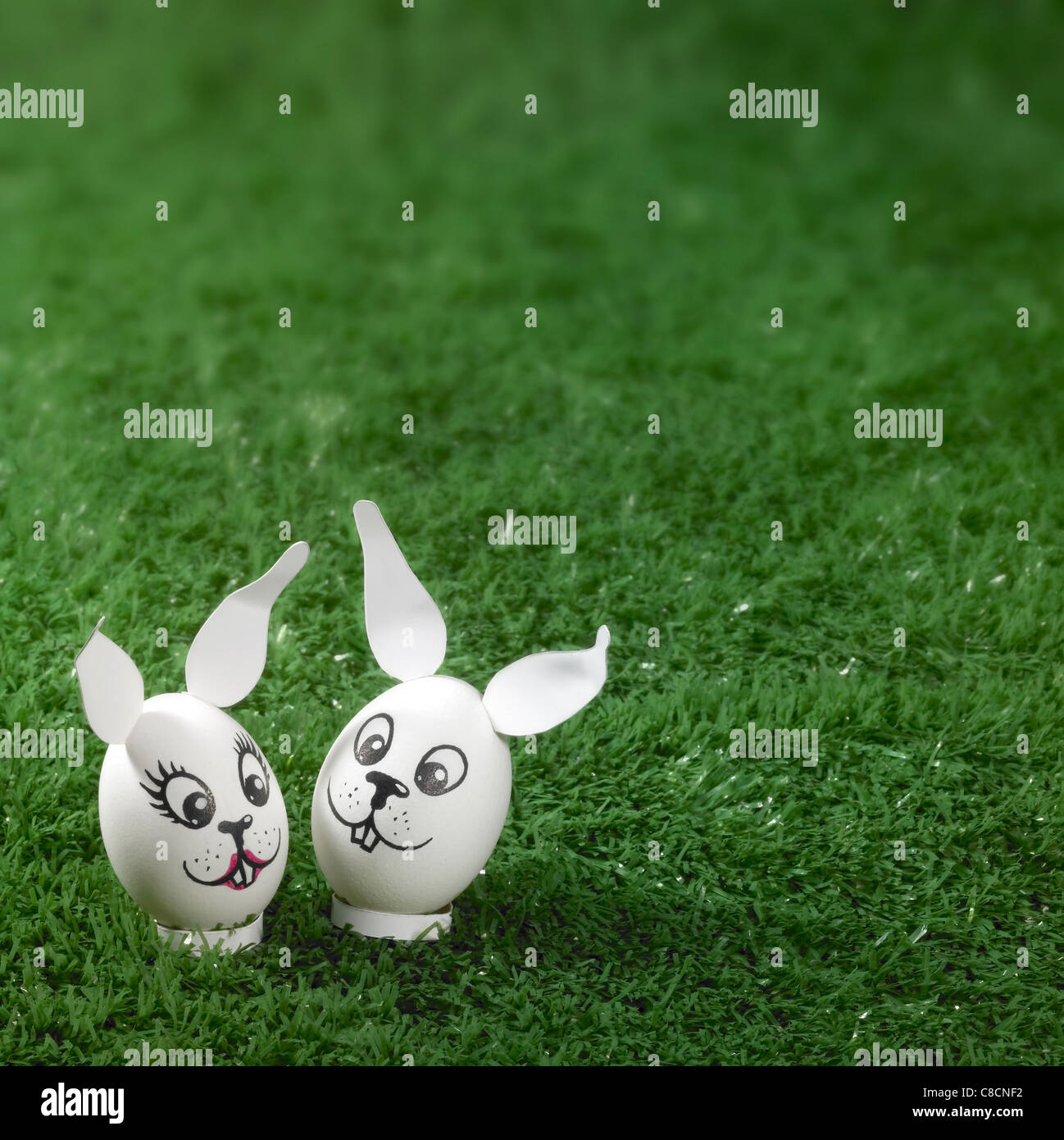 "Bunny" in stile uova di pasqua nel verde erba artificiale di sfondo Foto Stock