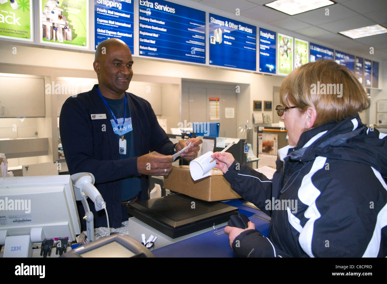 Cliente femmina e maschio americano africano lavoratore postale a Boise, Idaho, Stati Uniti d'America. Foto Stock