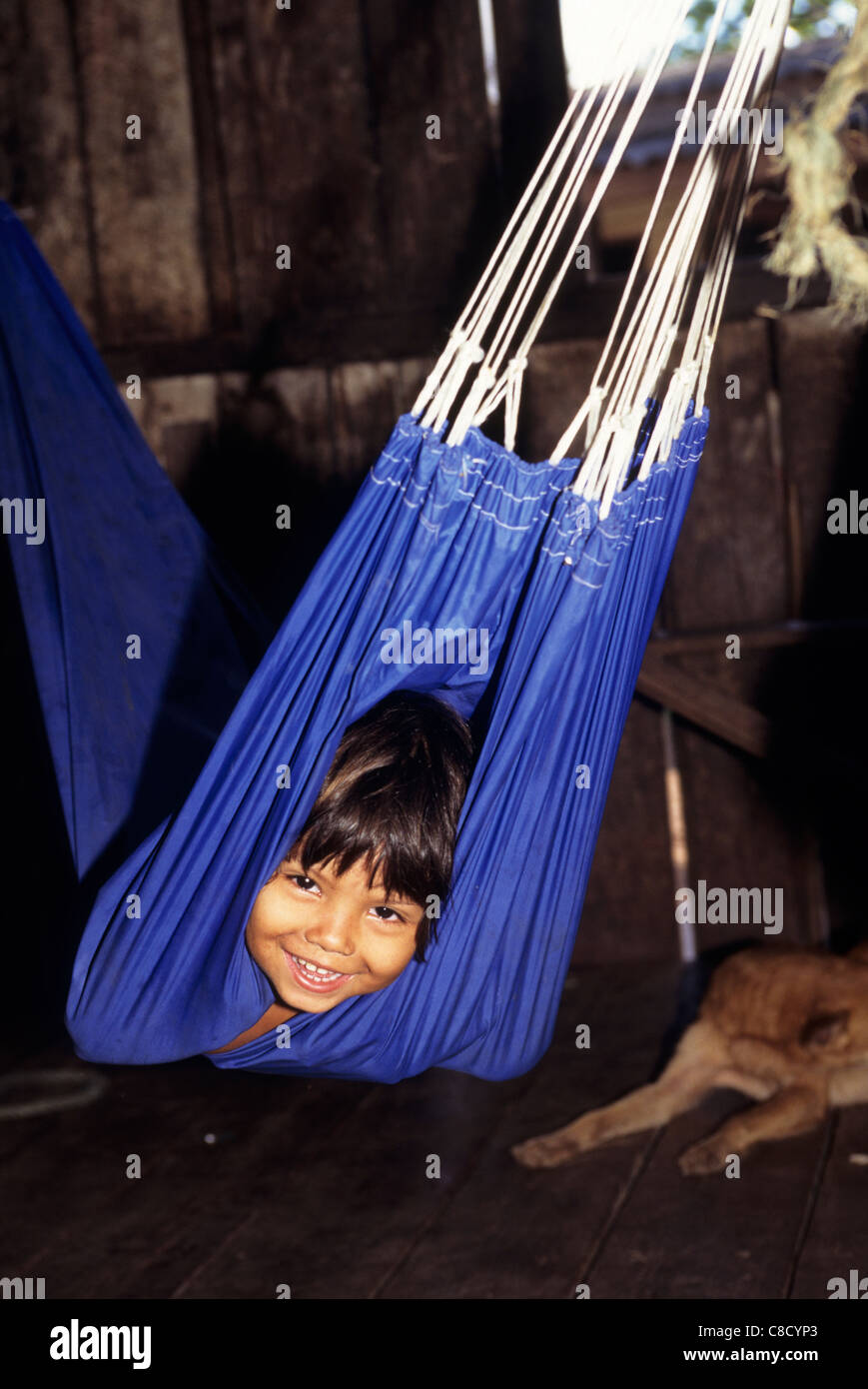 Amapa Affitto stato, Brasile. Sorridente caboclo bambino in un amaca blu. Foto Stock