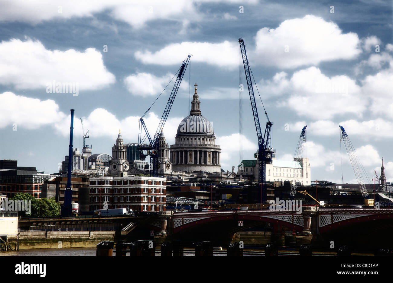 St Pauls Cathedral dome incorniciato dalle moderne gru, Londra in alto contrasto Foto Stock