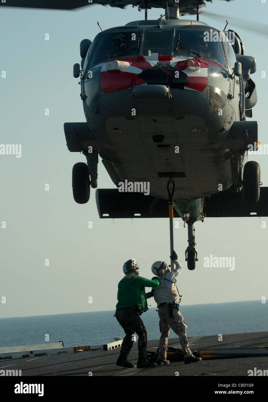 Il fissaggio di un gancio per un MH-60S Sea Hawk elicottero assegnato all'Eightballers di elicottero di mare squadrone di combattimento (HSC) 8 Foto Stock