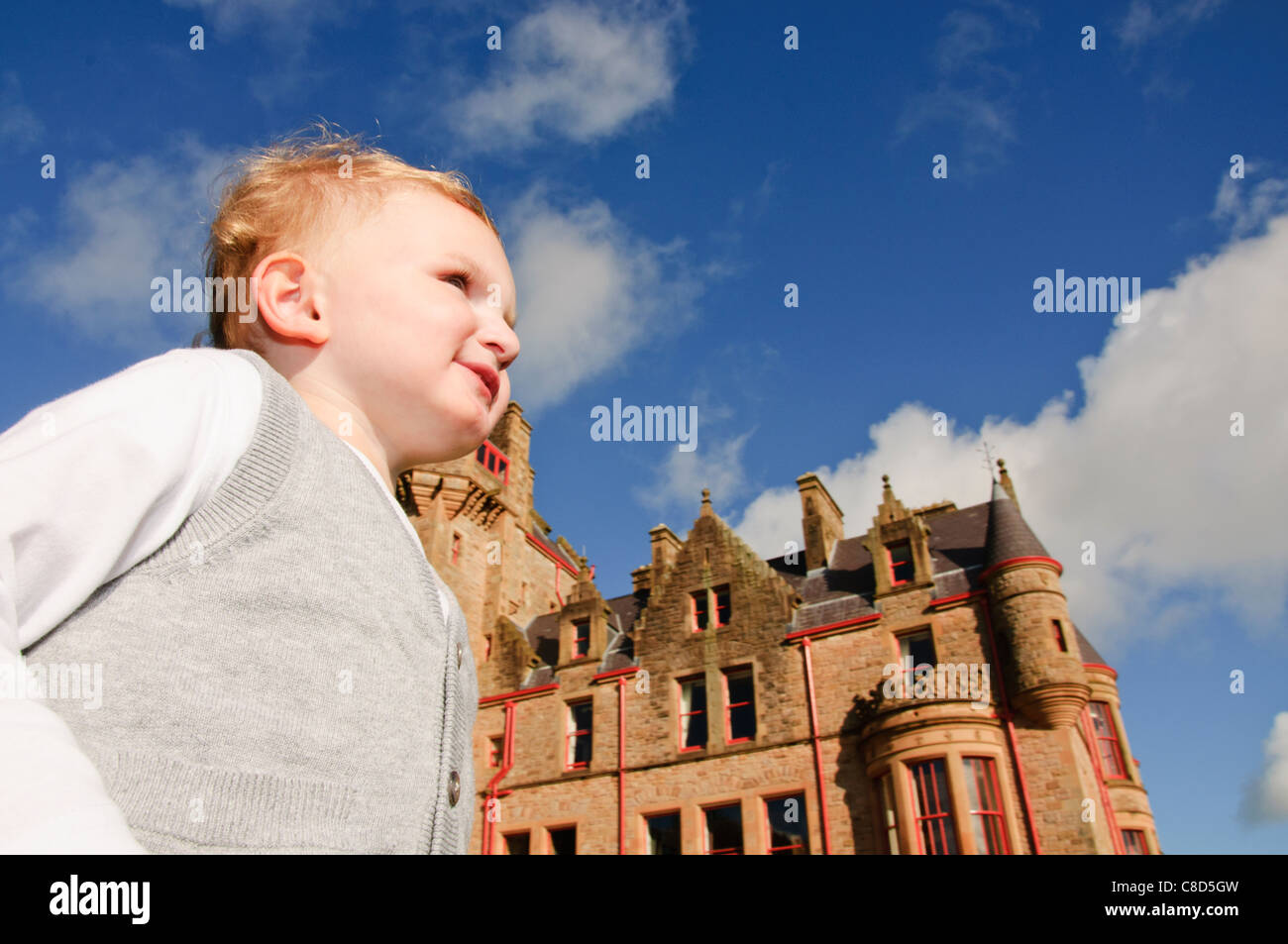 Un giovane bambino in posa per ritratto intorno al castello di Belfast Irlanda del Nord Foto Stock