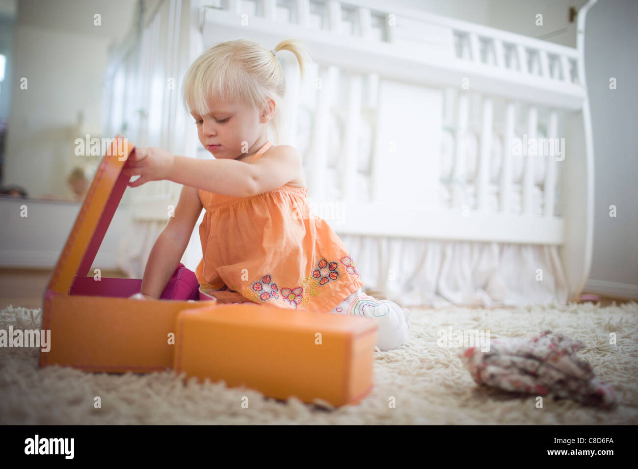 Il Toddler ragazza che gioca con la valigia Foto Stock