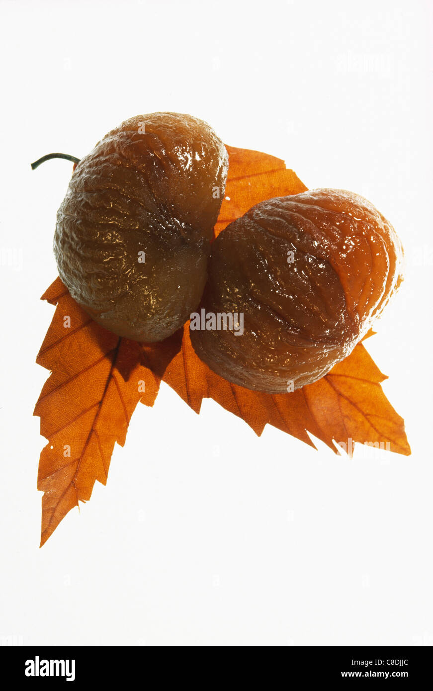 Marroni canditi e foglie di castagno Foto Stock
