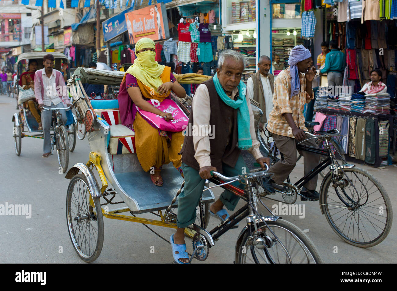 Scena di strada nella città santa di Varanasi, giovane donna musulmana in burkha colorate giostre in rickshaw, Benares, India settentrionale Foto Stock