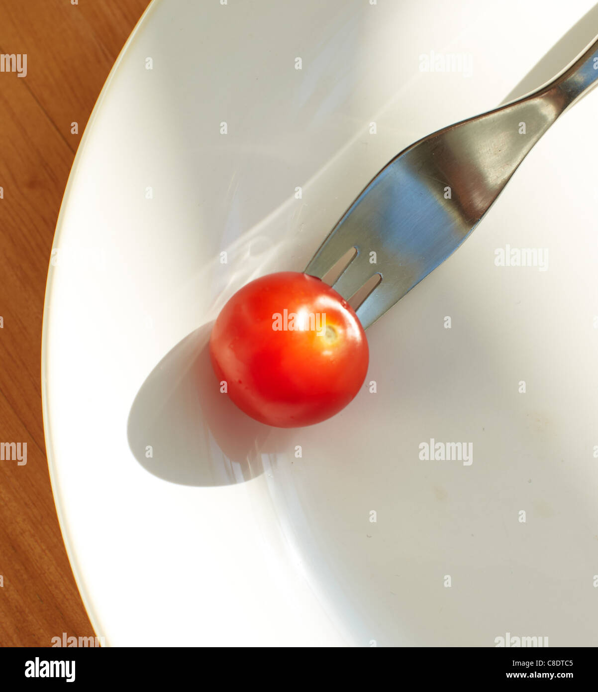 Pomodoro ciliegino sulla piastra con forca Foto Stock