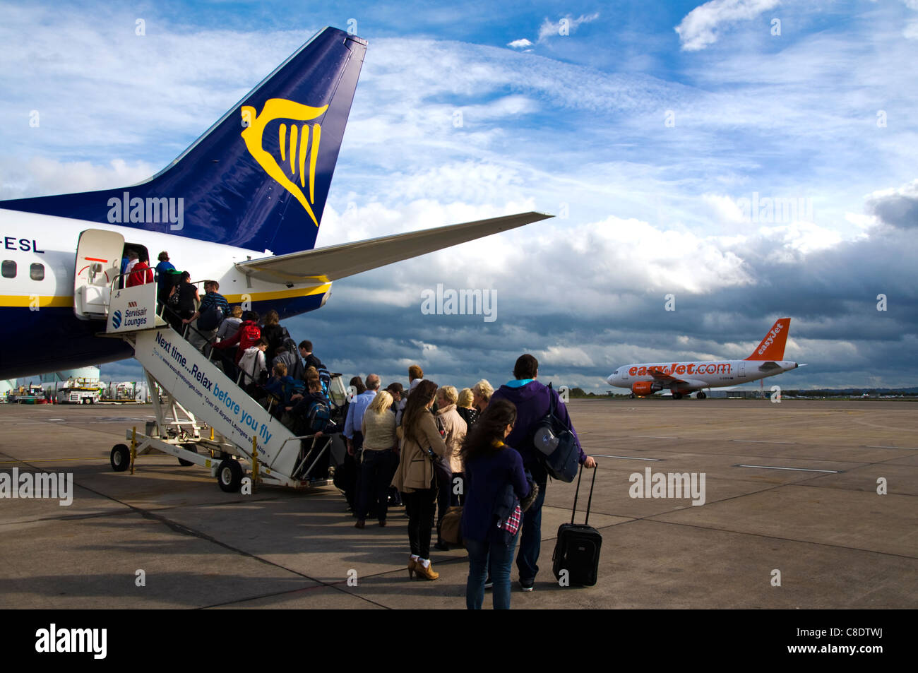 Coda di passeggeri a bordo di una Ryanair Boeing 737-800 piano come un aereo Easyjet terre Foto Stock