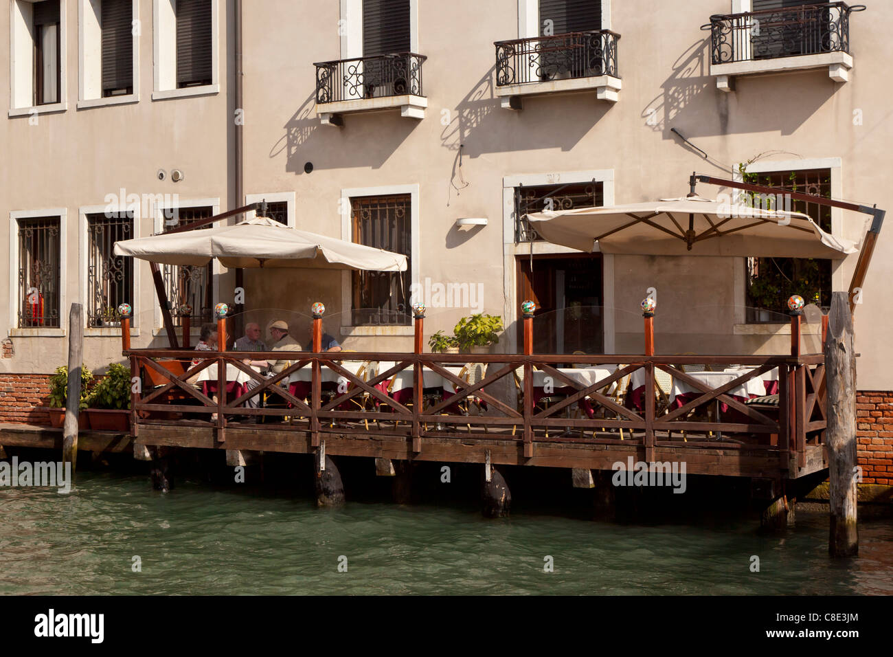 Un ristorante su una piattaforma su un canale di Venezia. Foto Stock