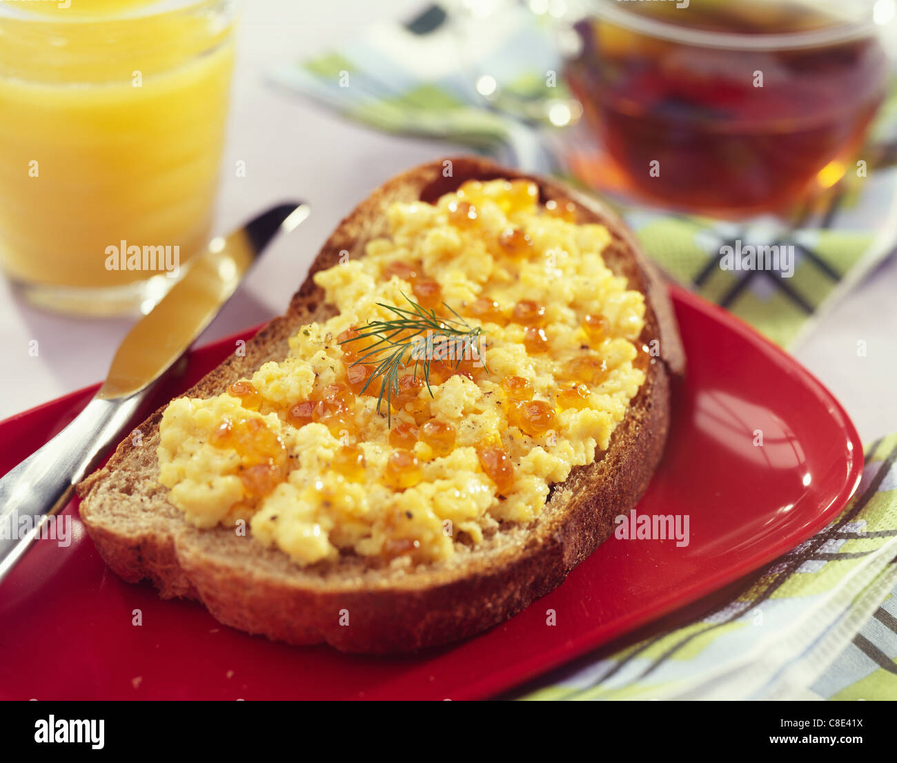 Uova strapazzate con Emmental e uova di salmone su una fetta di pane Foto Stock