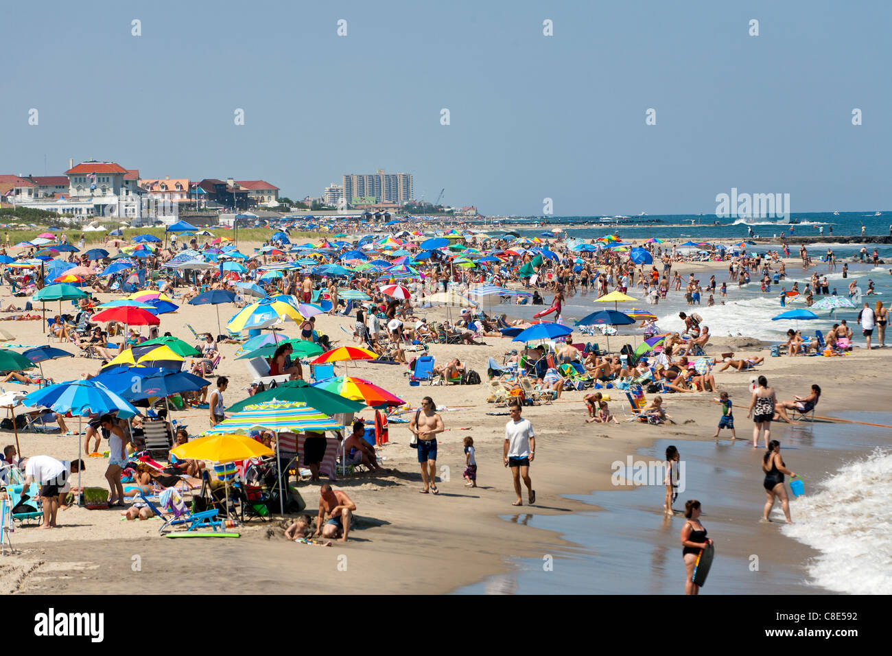 Le persone in vacanza e nuotare in un giorno di estate in spiaggia. Foto Stock