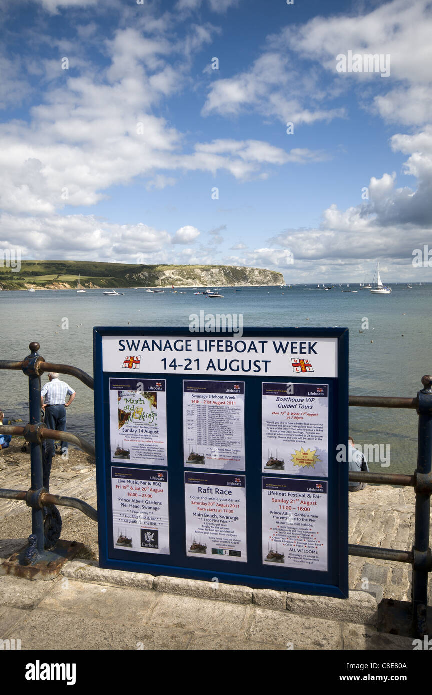 Segno di informazioni sul porto di Swanage circa Swanage scialuppa di salvataggio settimana con Ballard punto della distanza, Dorset, England, Regno Unito Foto Stock