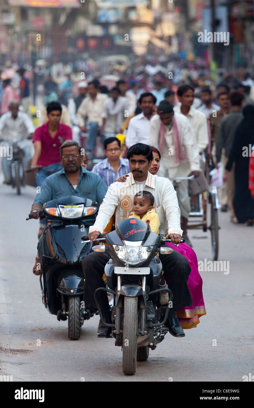 Gruppo di famiglia sul motociclo in strada affollata scena durante la festa di Shivaratri nella città di Varanasi, India Foto Stock