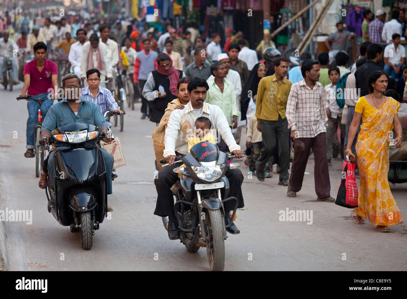 Gruppo di famiglia sul motociclo in strada affollata scena durante la festa di Shivaratri nella città di Varanasi, India Foto Stock