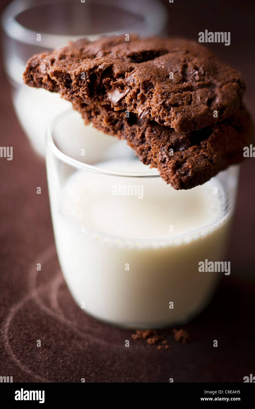 Biscotti al cioccolato e un bicchiere di latte Foto Stock