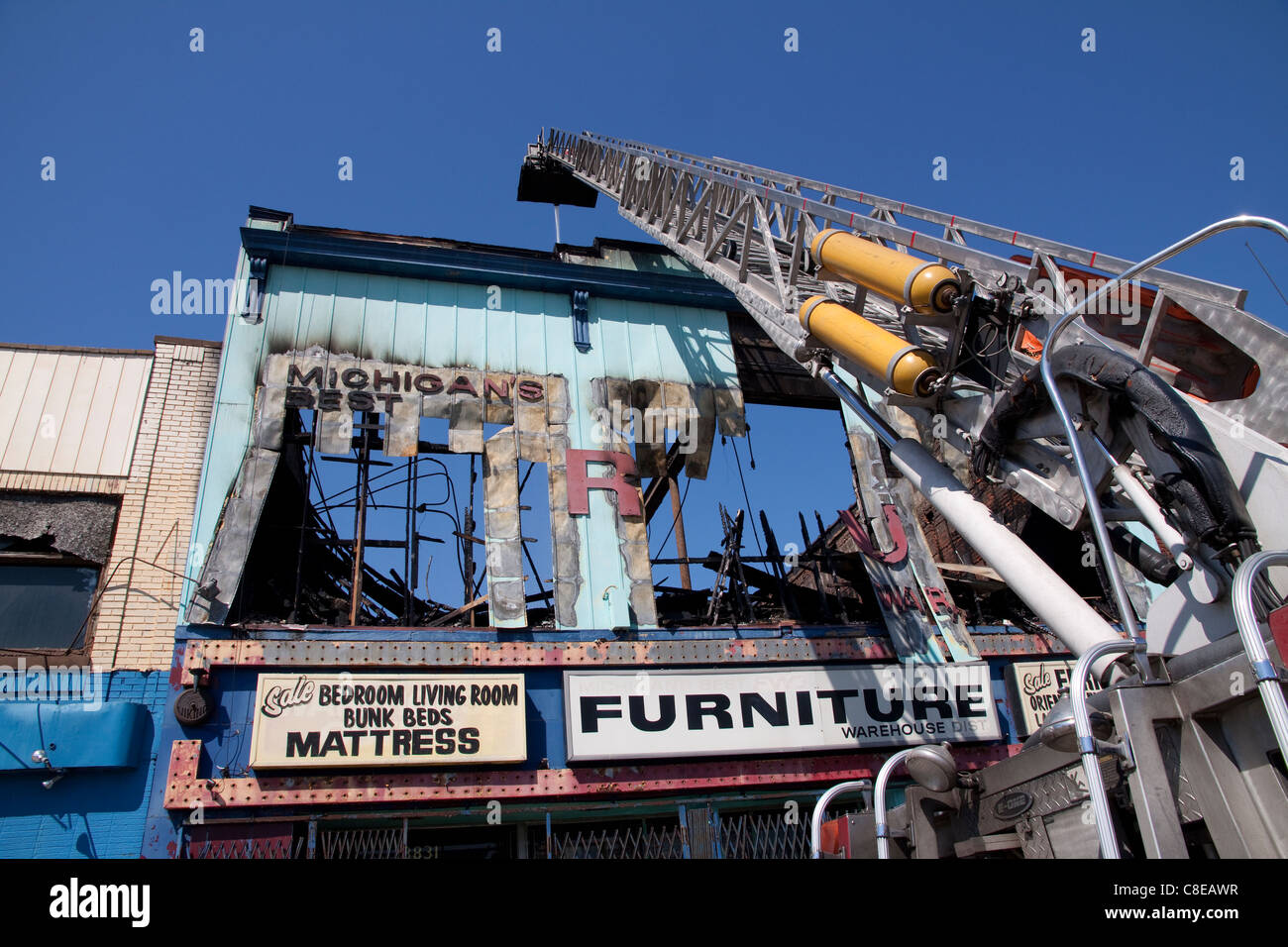 Piattaforma aerea versando acqua sulla scia di arson edificio commerciale fire in Highland Park vicino a Detroit Michigan STATI UNITI Foto Stock