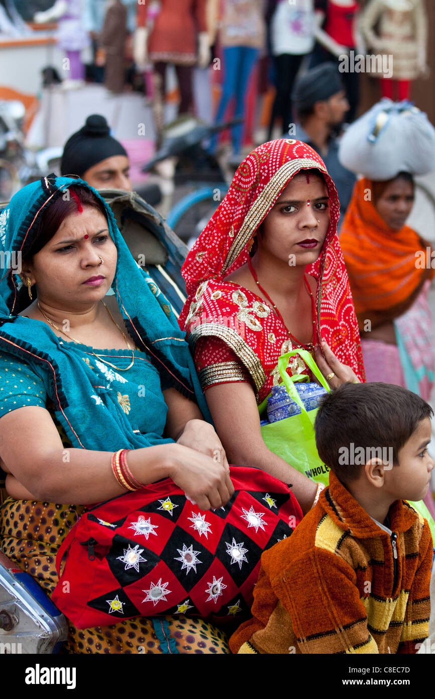 Le donne indiane corsa in rickshaw in strada affollata scena nella città di Varanasi, Benares, India settentrionale Foto Stock