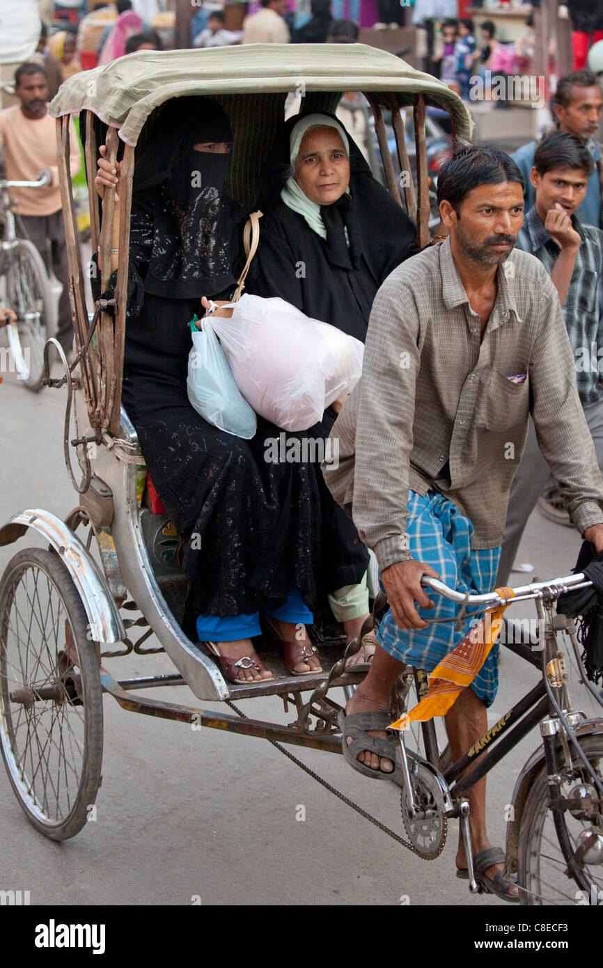 Le donne musulmane corsa in rickshaw in strada affollata scena nella città di Varanasi, Benares, India settentrionale Foto Stock