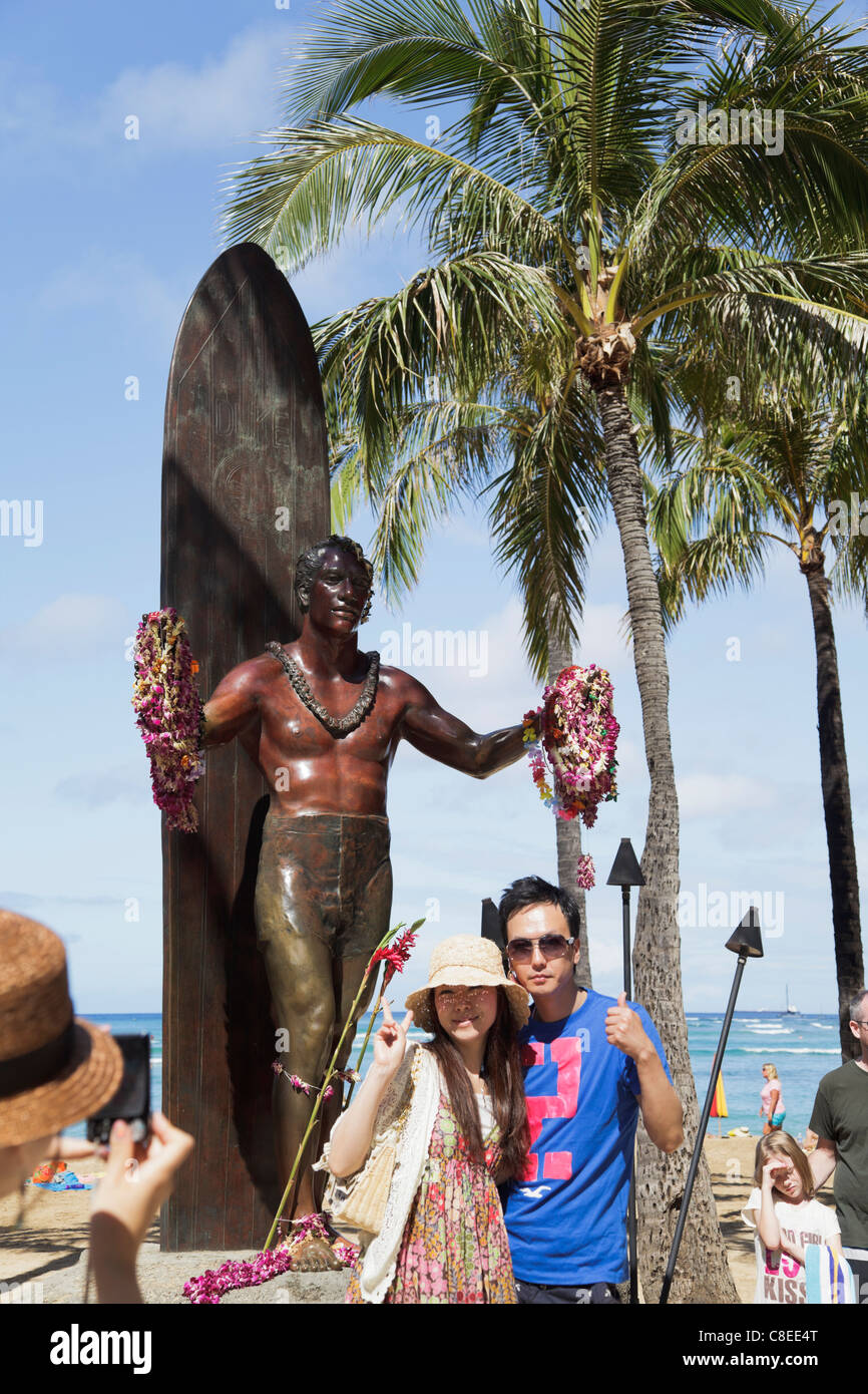 Per solo uso editoriale: un giovane pone di fronte al Duke Kahanamoku statua sulla spiaggia di Waikiki a Honolulu, Oahu, Hawaii. Foto Stock
