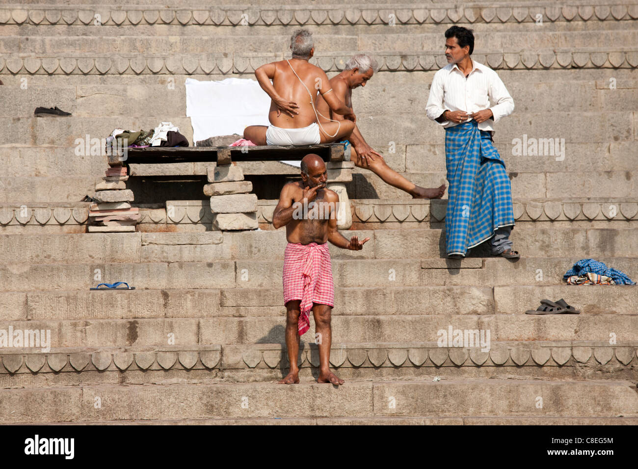 Gli uomini la balneazione a Dharbanga Ghat dal fiume Gange nella città di Varanasi, Benares, India settentrionale Foto Stock
