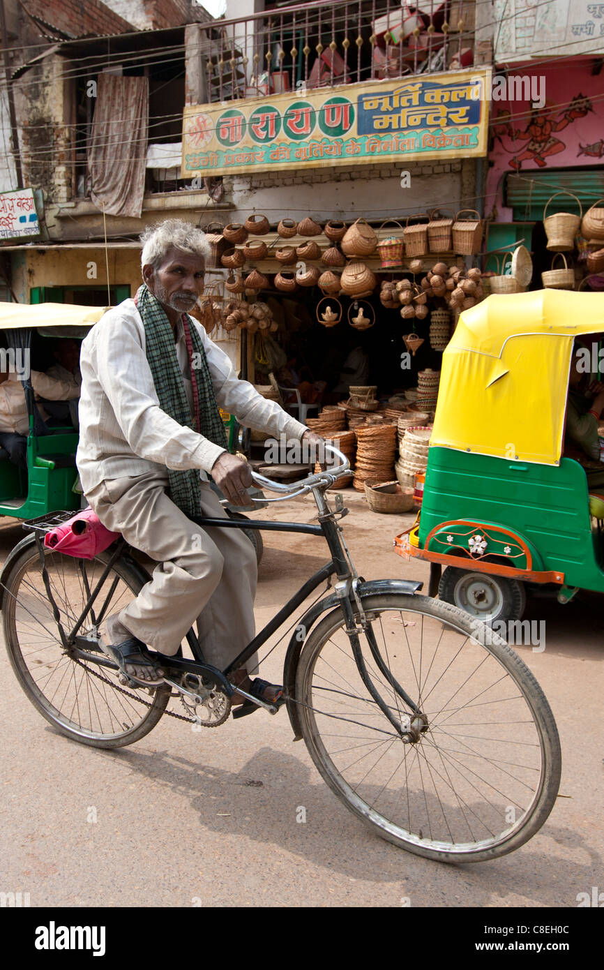 Indian uomo Bicicletta Equitazione scena di strada nella città di Varanasi, Benares, India settentrionale Foto Stock