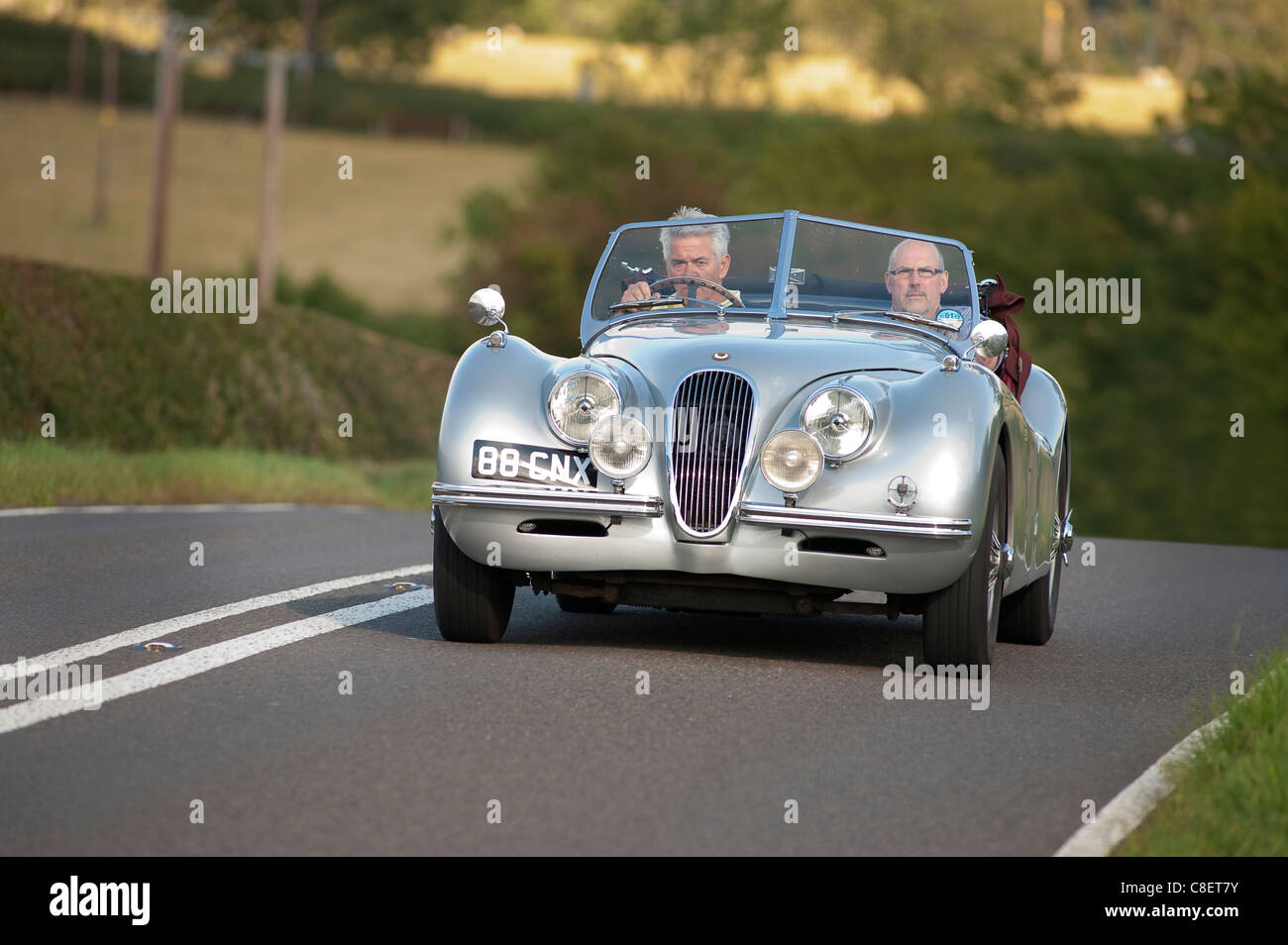 Classic Jaguar XK-120 roadster auto viene guidato su una strada in Inghilterra. Foto Stock
