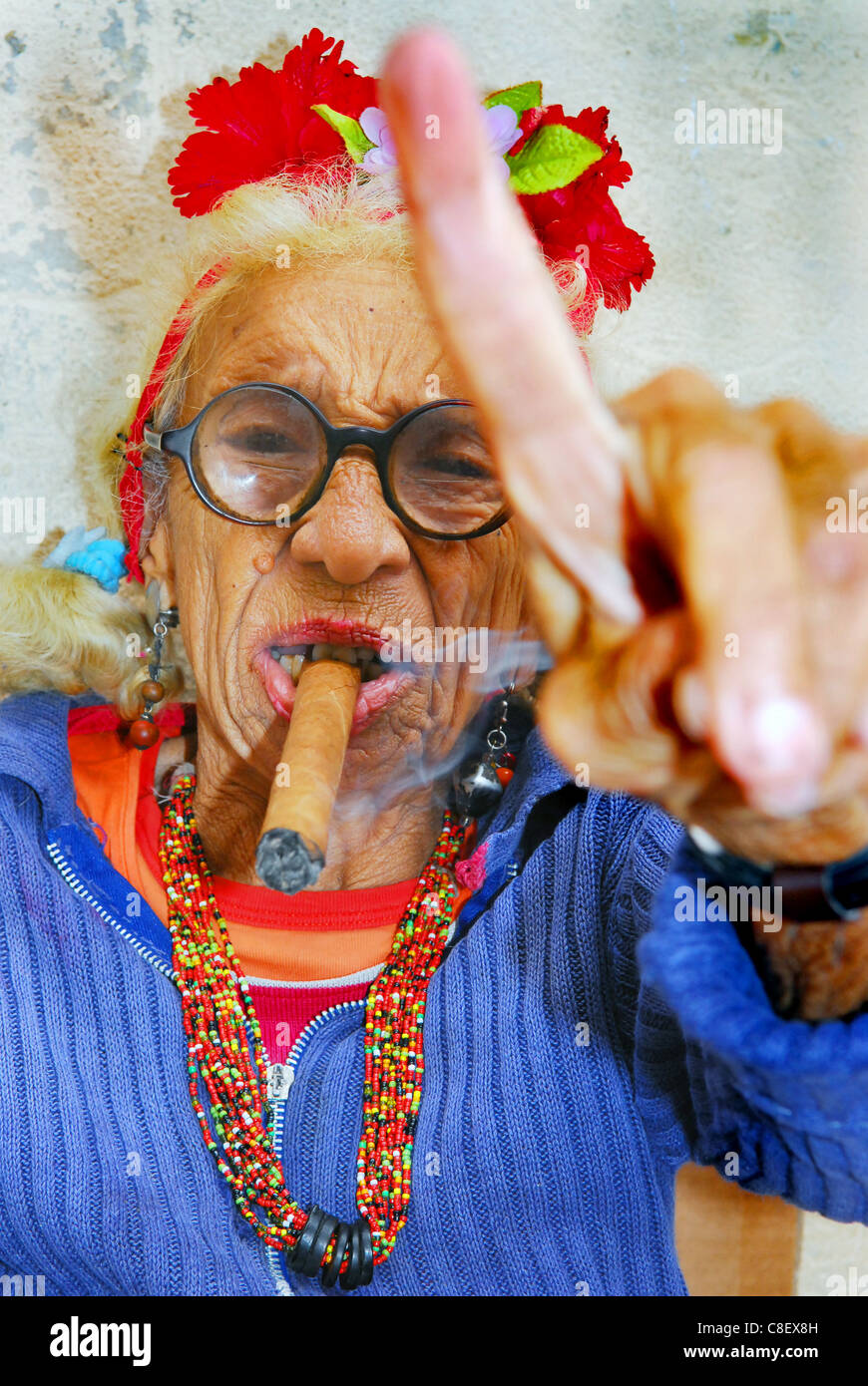 Exentric vecchia signora cubano con grande sigaro e puntare il dito per le strade di La Habana, Cuba Foto Stock