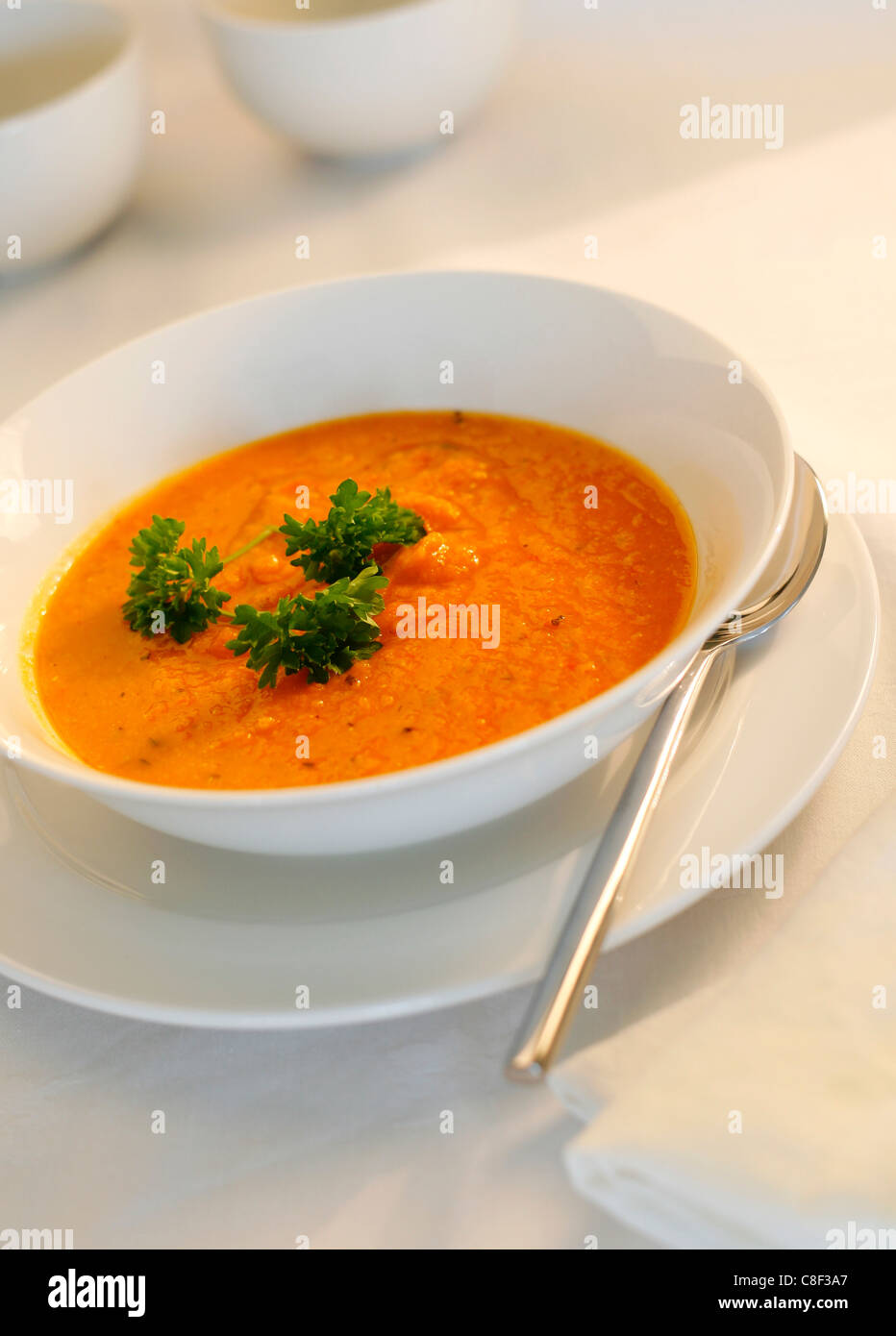 Zuppa di zucca contro un bianco/sfondo luminoso con la piastra e il cucchiaio Foto Stock