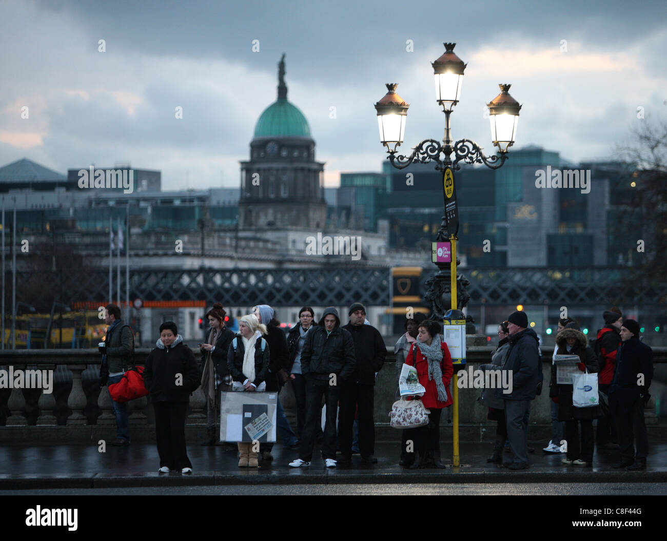 La mattina presto pendolari aspettare ad una fermata di autobus di Dublino, Irlanda Foto Stock