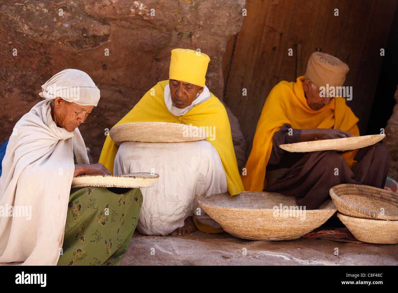 Le monache di grano di smistamento in Bet Maryam chiesa cortile, Lalibela, Wollo, Etiopia Foto Stock
