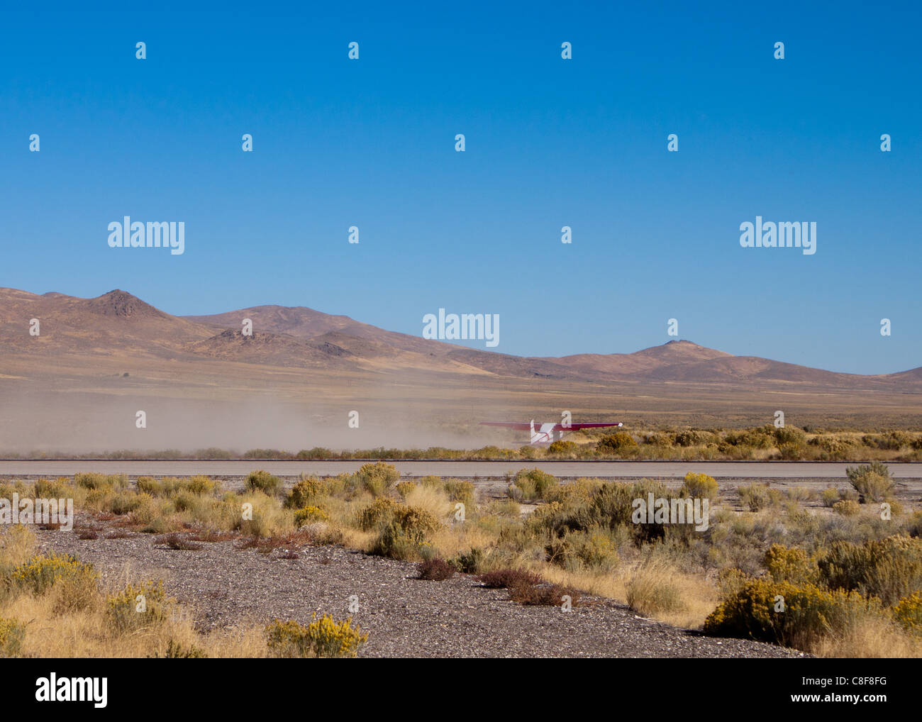 Una bella immagine di un aereo che di su un deserto polveroso pista. Foto Stock