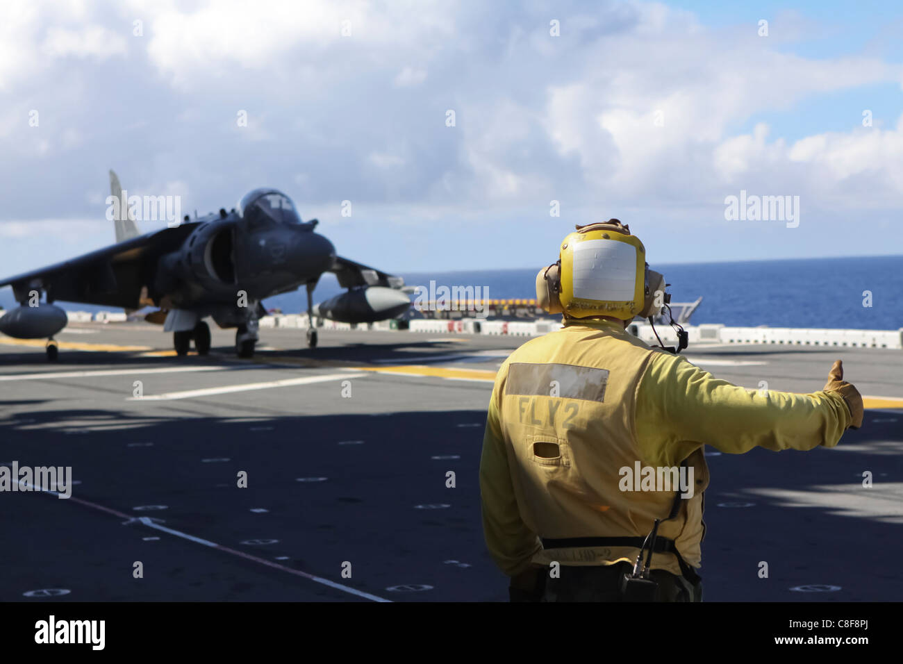 Un controllore del traffico aereo fornisce un AV-8B Harrier con attacco Marino Squadron 214 un pollice in alto prima del decollo Foto Stock