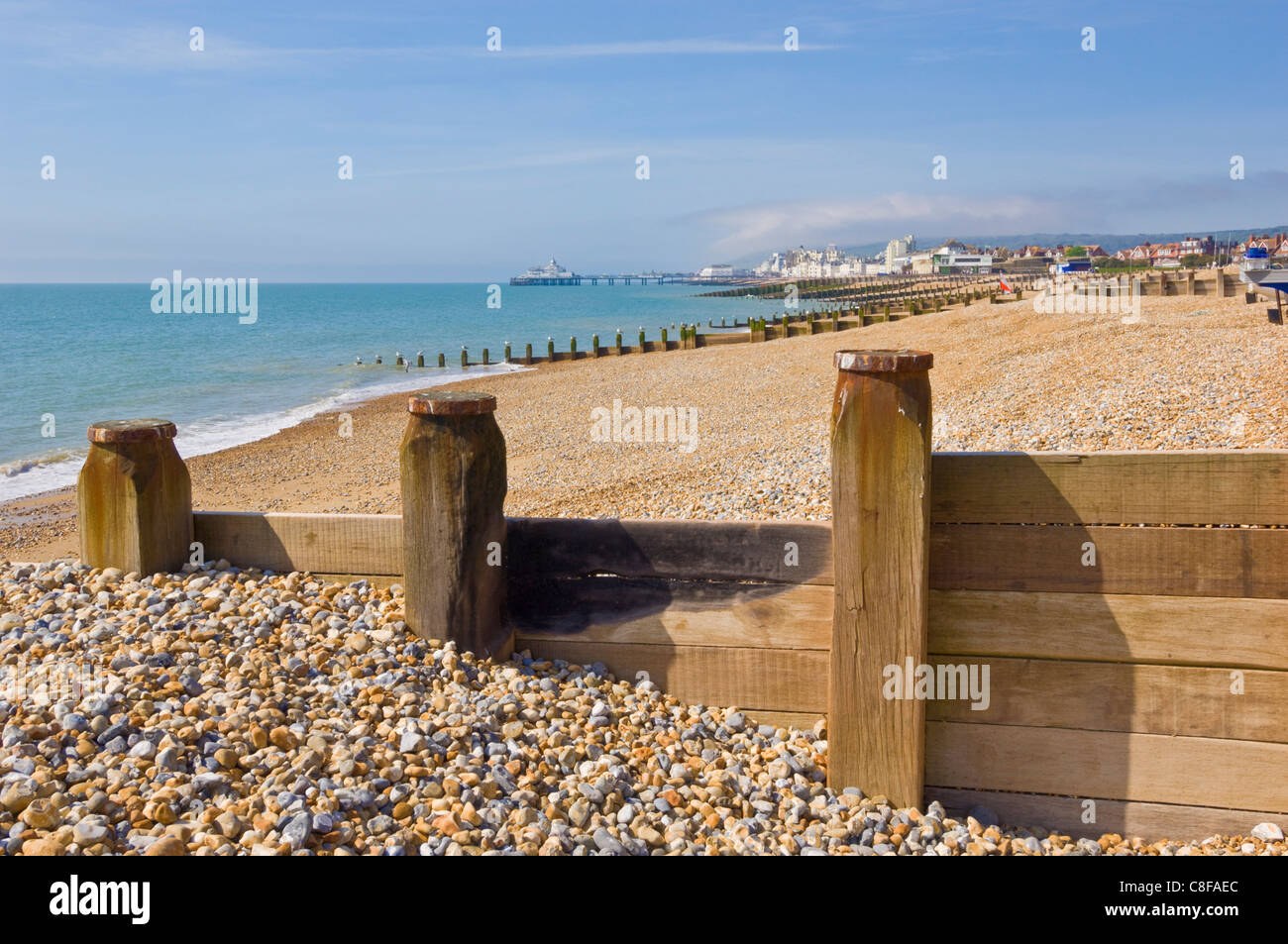 Spiaggia ghiaiosa e pennelli, Eastbourne Pier nella distanza, Eastbourne, East Sussex, England, Regno Unito Foto Stock