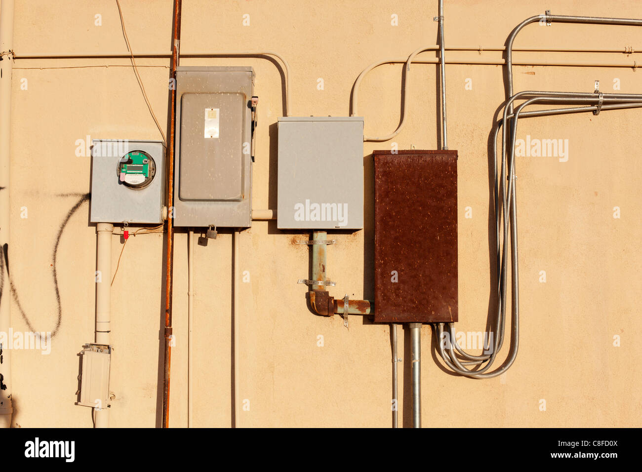 Contatore elettrico e le scatole dei fusibili sul lato di una parete. Foto Stock
