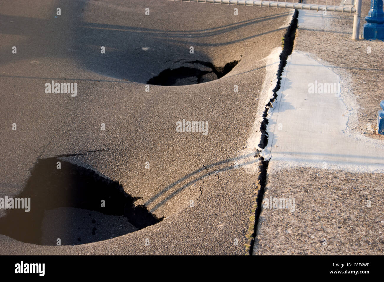 Fori di subsidenza in passeggiata dopo il lavoro per la difesa del mare Foto Stock