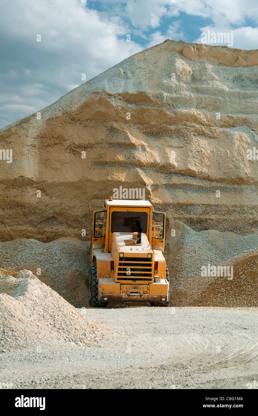 Bulldozer nella cava. Enorme pila di calcare e sabbia Foto Stock