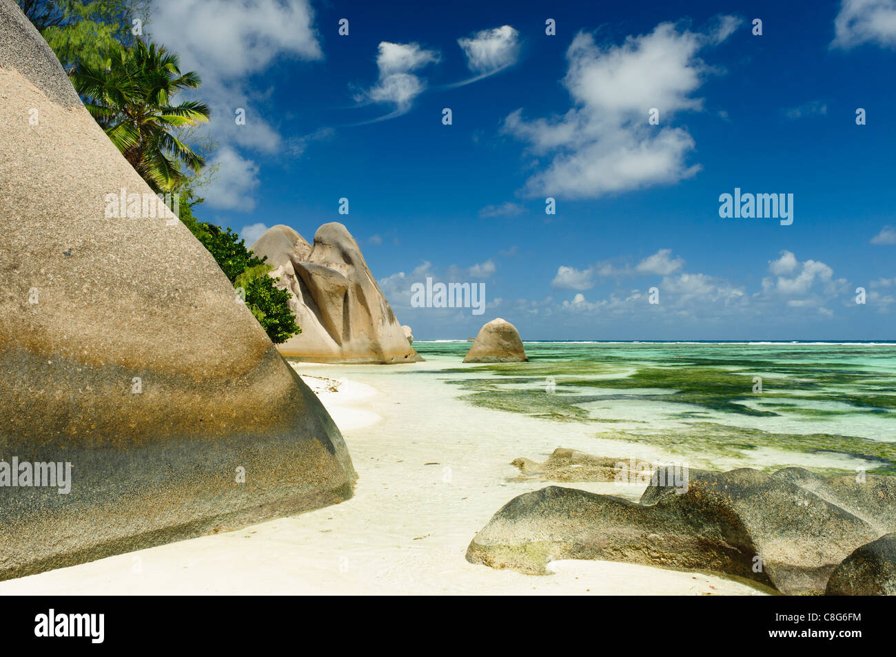 Appartata fetta di spiaggia di sabbia tra sfondo di gigantesche rocce di granito e acque turchesi con suoni lulling dell'oceano Foto Stock