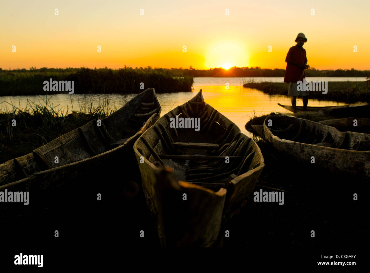 Le riparazioni del pescatore il suo net al tramonto, Canal des Pangalanes, Mankara, Madagascar, Oceano Indiano Foto Stock