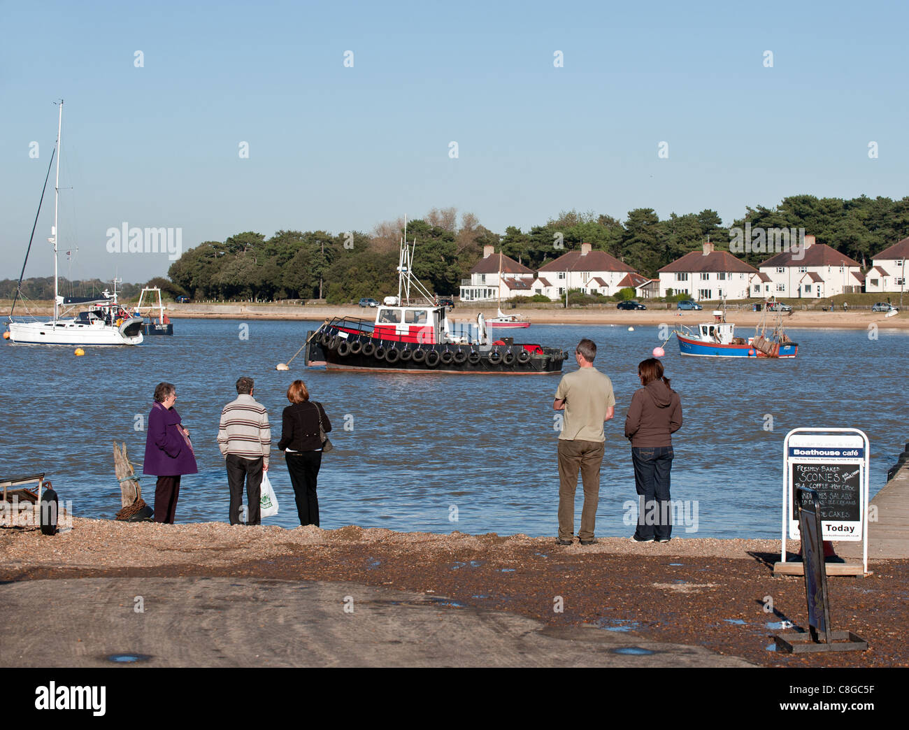 Persone in piedi sulle rive del fiume Deben a Felixstowe Ferry Foto Stock