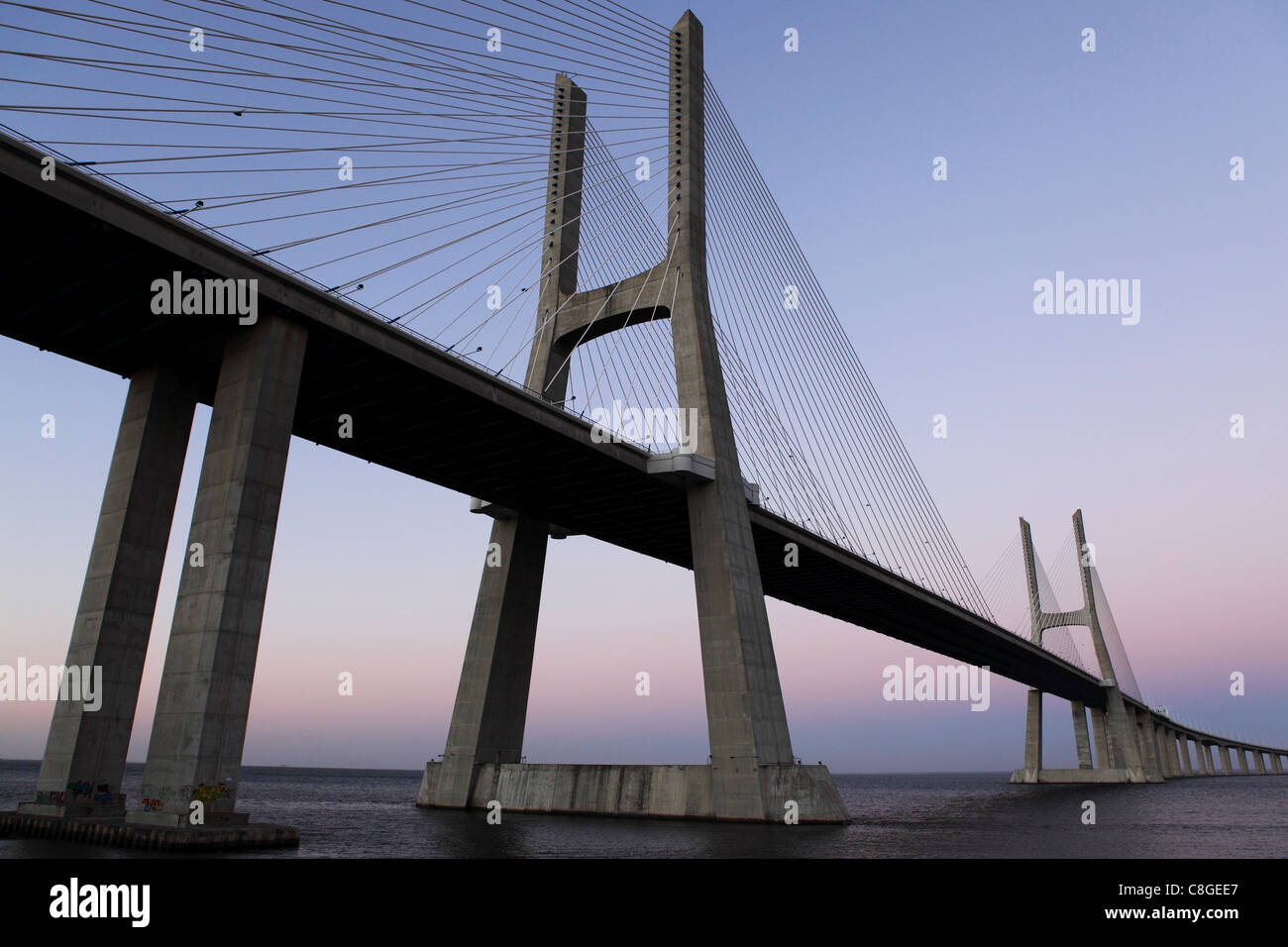 Crepuscolo presso il ponte Vasco da Gama sul fiume Tago (Rio Tejo) a Lisbona, Portogallo Foto Stock