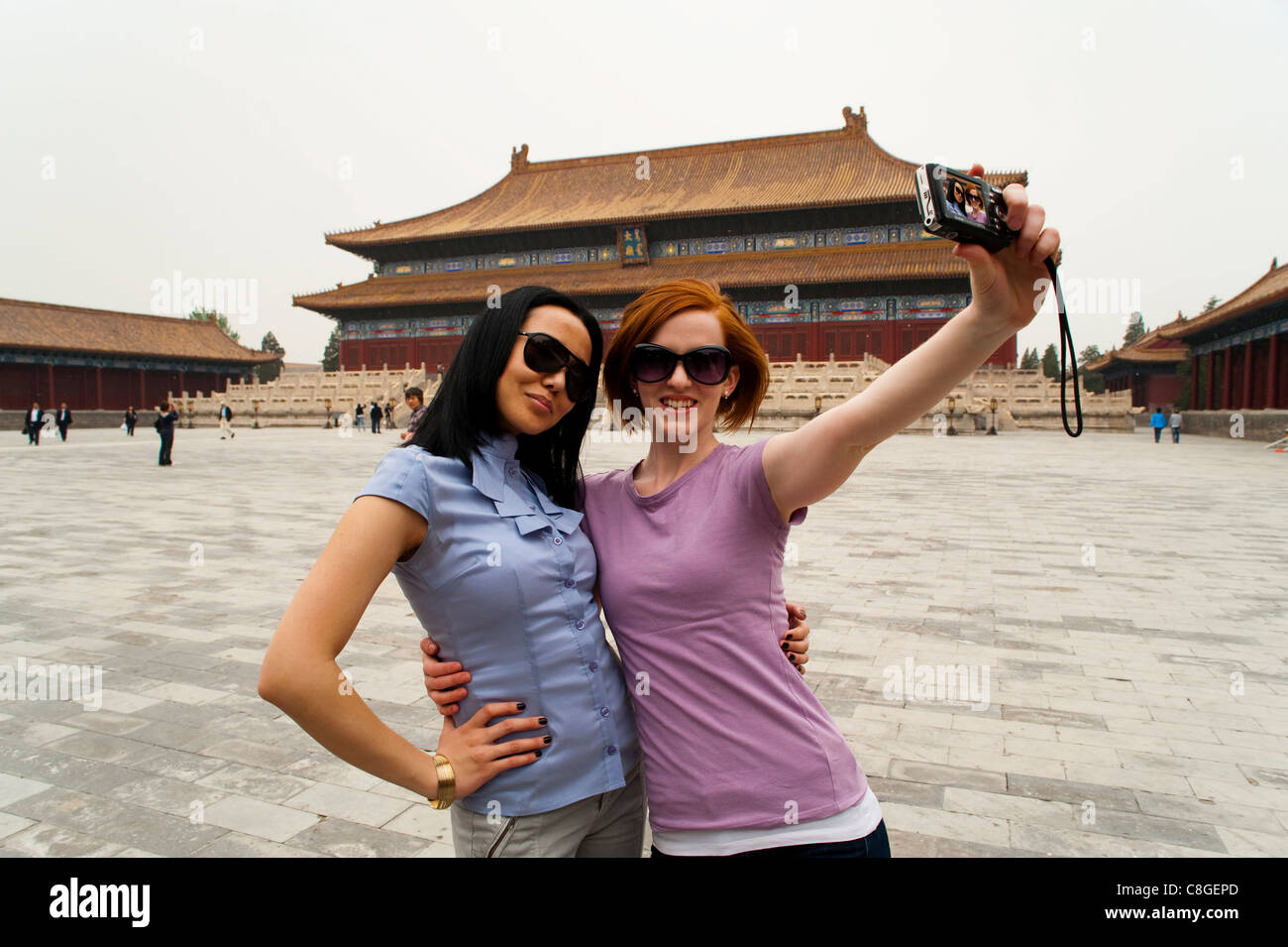 I turisti tenendo la propria fotografia di fronte alla sala per il culto degli antenati, la Città Proibita di Pechino, Cina Foto Stock