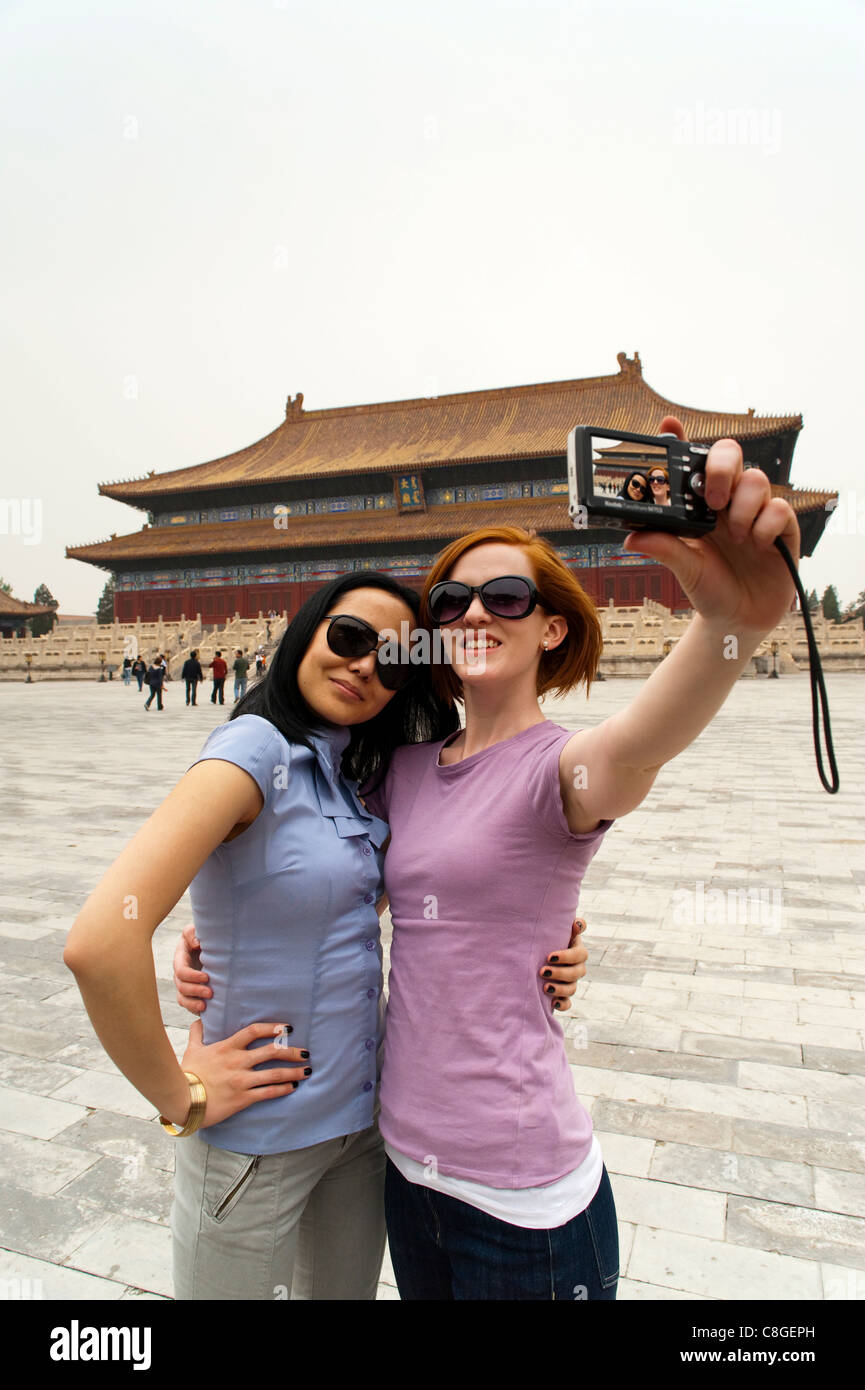 I turisti tenendo la propria fotografia di fronte alla sala per il culto degli antenati, la Città Proibita di Pechino, Cina Foto Stock