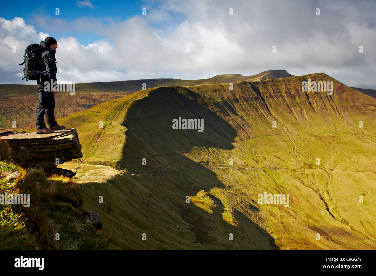 Lone permanente maschio sulla ventola y grande trampolino ammirando la vista con il Mais Du, Pen y la ventola e Cribyn, Brecon Beacons NP Foto Stock