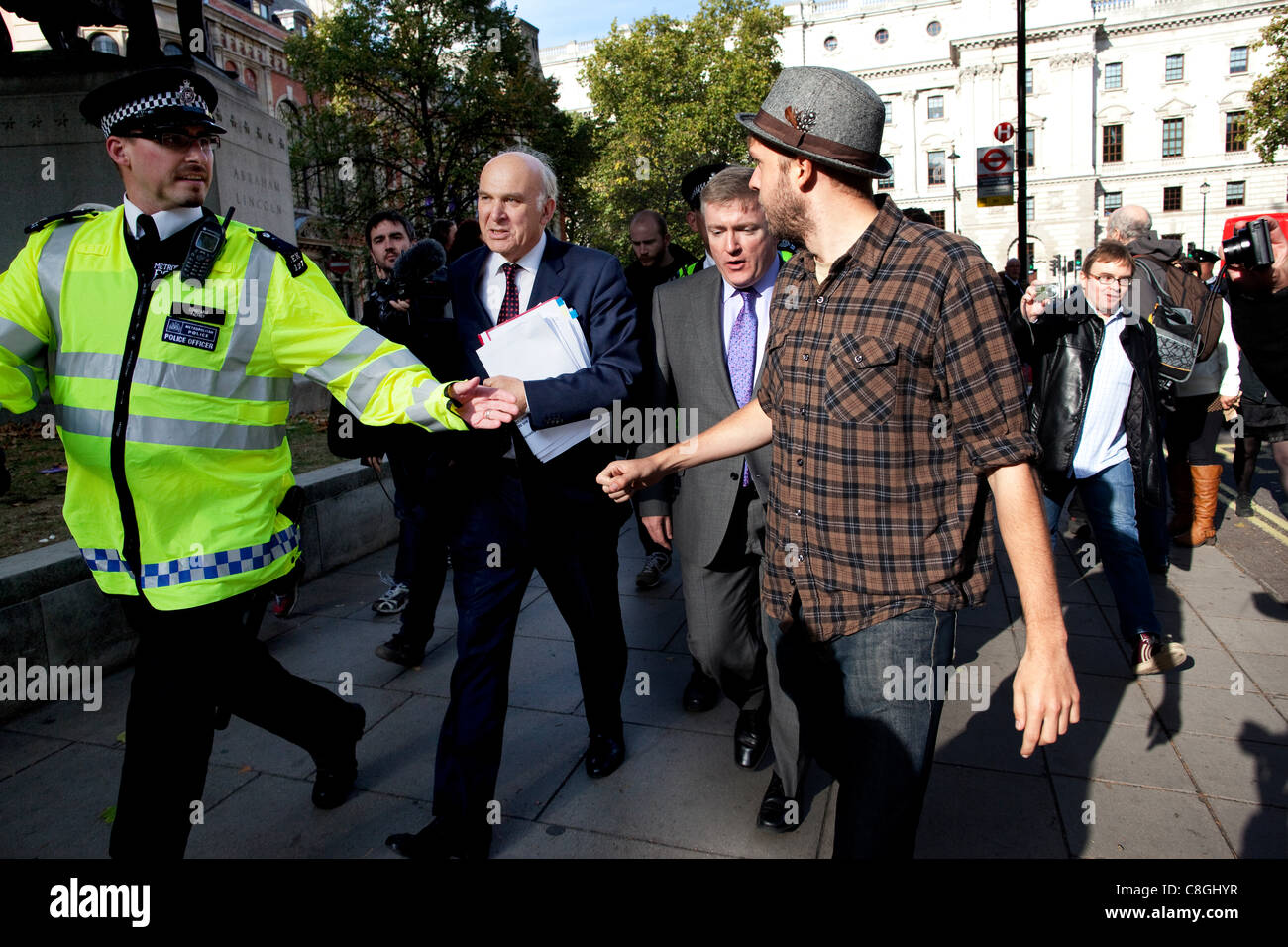 Vince il cavo, il Segretario aziendale, si trova di fronte a manifestanti contrari alla "corporate tax dodging' come egli cammina da Whitehall a Victoria Street, Londra, Regno Unito, lunedì 24 ottobre, 2011. Foto Stock