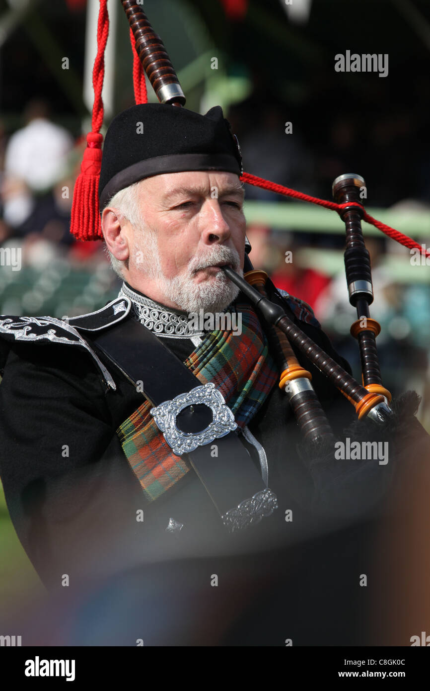 Villaggio di Braemar, Scozia. Un piper da Blairgowrie e Rattary District Pipe Band presso il Braemar raccolta di giochi. Foto Stock