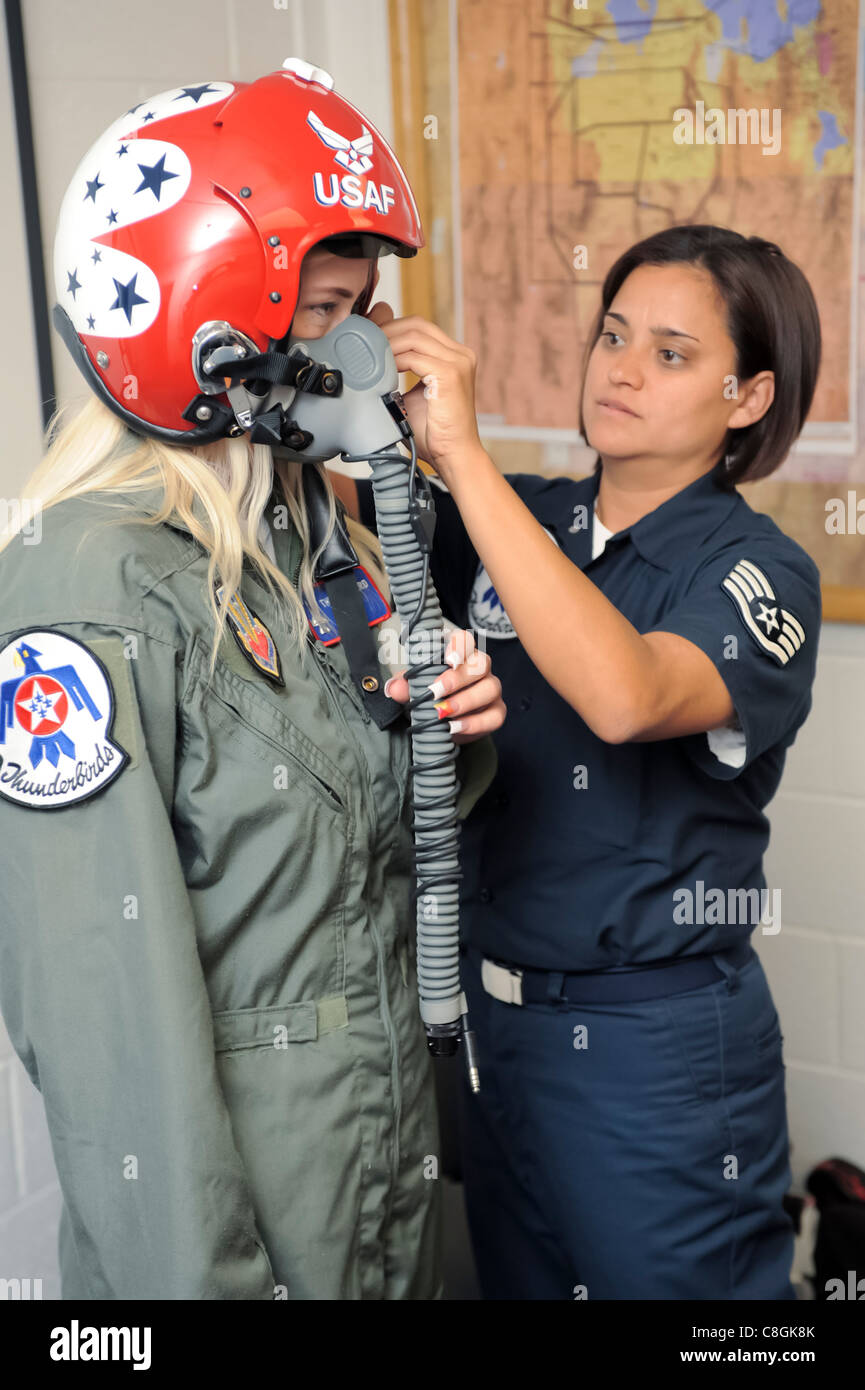 Staff Sgt. Robbin Bailon, un tecnico di equipaggiamento di volo Air Force Thunderbirds, regola il casco e la maschera facciale su Megan Funk durante il suo adattamento di tuta di volo 4 giugno presso la base dell'aeronautica di Hill, Utah. La signora Funk, una seconda insegnante di scuola elementare Majestic a Ogden, Utah, è stata selezionata come Hometown Hero per il suo servizio volontario alla comunità per la quale ha ricevuto un volo in un Thunderbird F-16 Fighting Falcon. Foto Stock