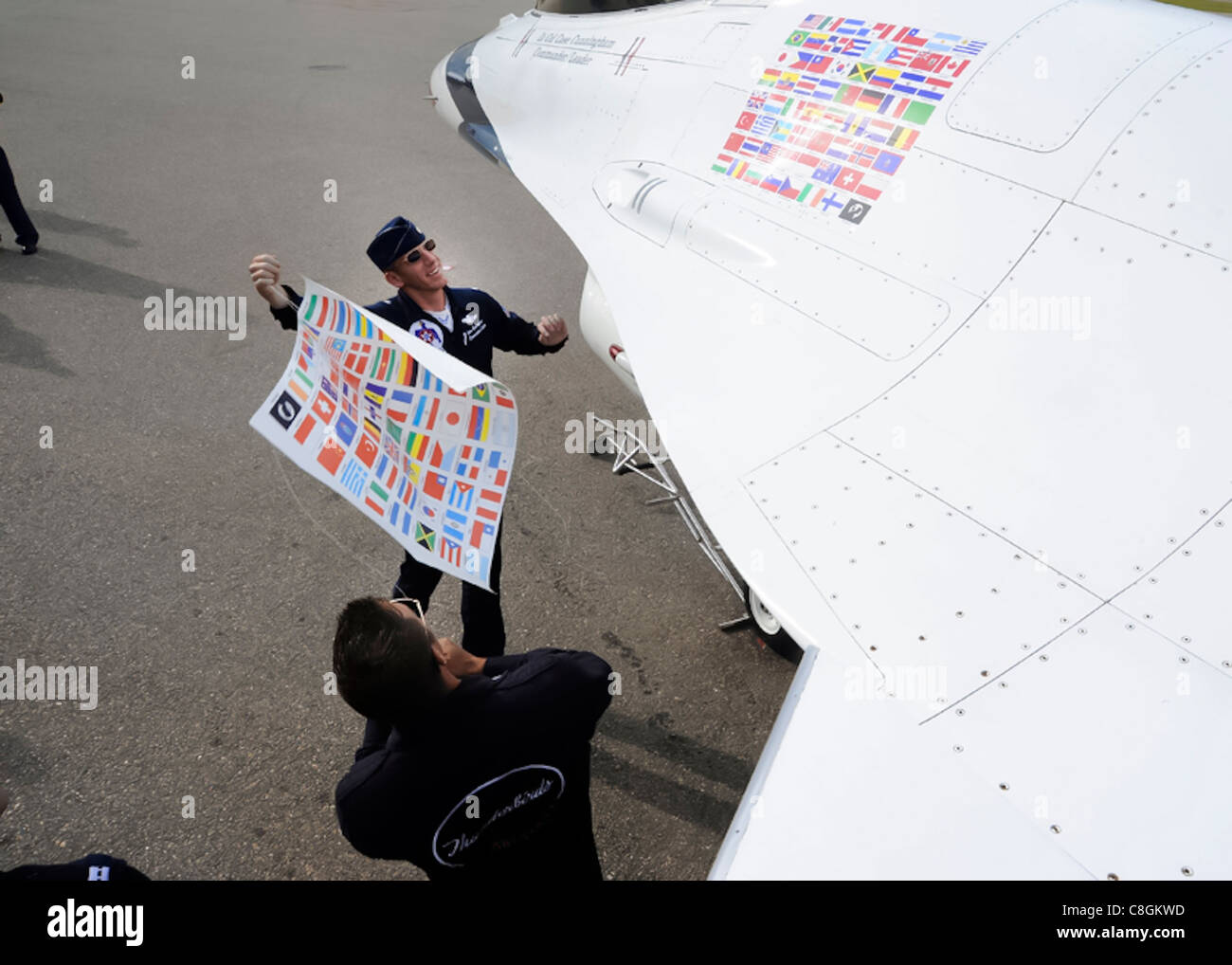 BrLt. Col. Case Cunningham, Thunderbird No. 1, e Tech. SGT. Paul DeGrechie tira fuori il vecchio pannello di bandiera, rivelando il nuovo pannello con la bandiera della Finlandia alla base aerea di Turku, Finlandia, 18 giugno 2011. Questo segna la prima volta nella storia di 58 anni della squadra a volare in Finlandia. I Thunderbirds si esibiranno in nove paesi durante il loro tour europeo, promuovendo la buona volontà internazionale e rappresentando gli Airmen americani in tutto il mondo. Foto Stock