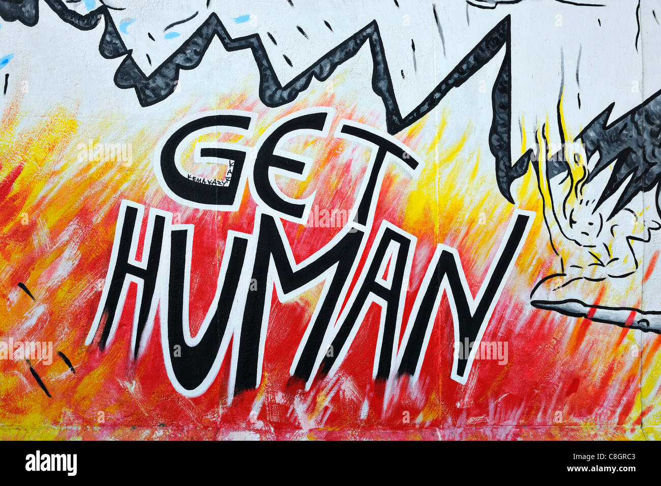 Murale chiamato 'umani' sul muro di Berlino a East Side Gallery di Berlino in Germania, Europa Foto Stock